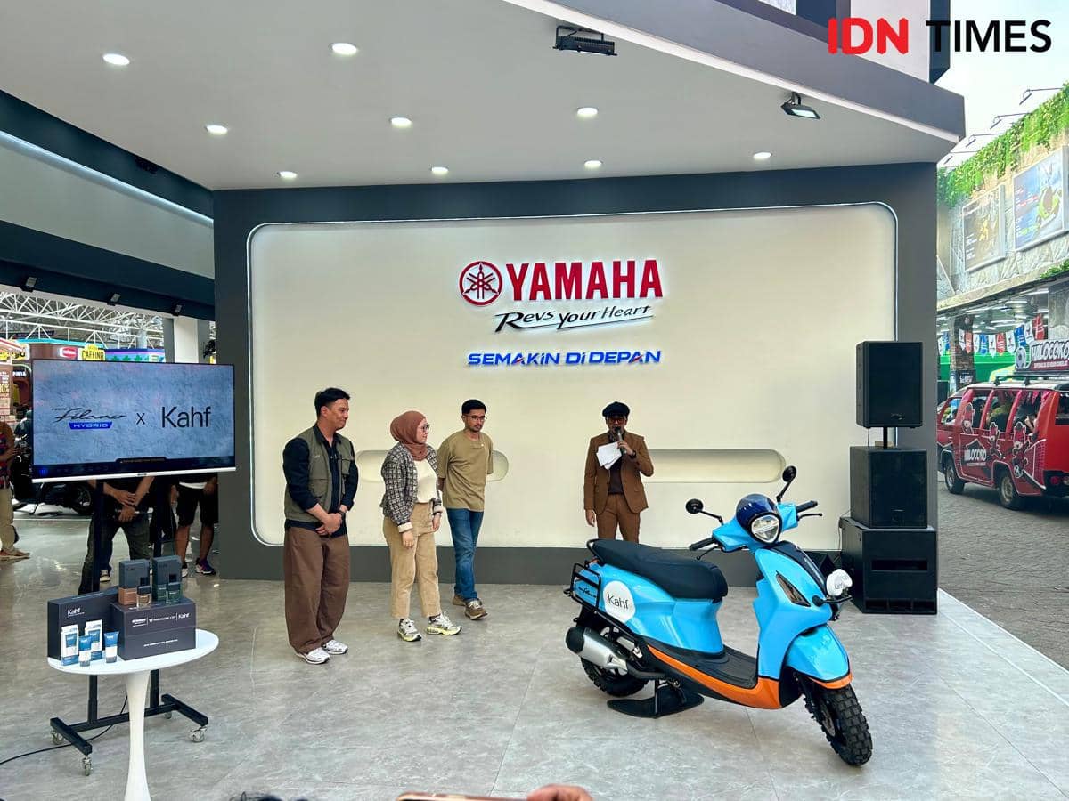 Beberapa orang berdiri di panggung pameran Yamaha dengan motor skuter biru dan layar bertuliskan kolaborasi Yamaha x Kahf di JFK 2026.