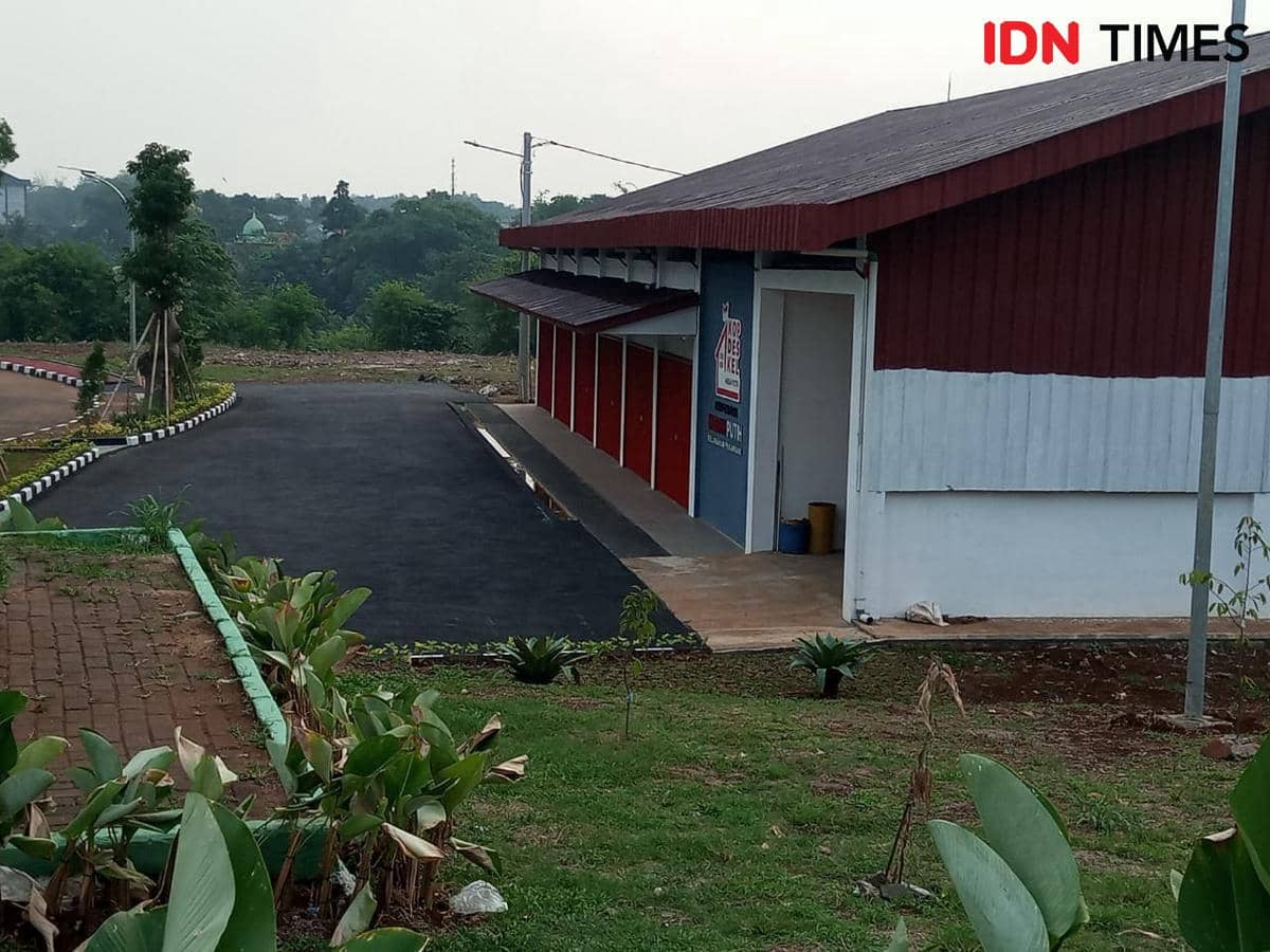 Bangunan Gerai Kopdes Merah Putih di Pakansari Bogor dengan dinding merah putih dan jalan aspal di sampingnya.
