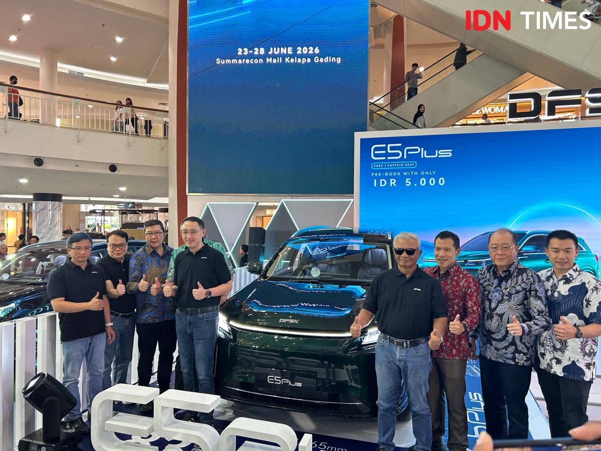 Sejumlah pria berpose di depan mobil listrik DFSK E5 Plus saat acara pembukaan pre-booking di Summarecon Mall Kelapa Gading.