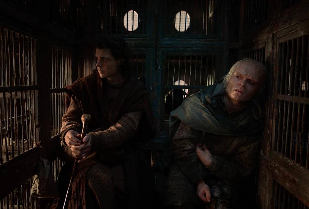 Dua karakter duduk di dalam kereta besi gelap dengan ekspresi serius dalam adegan serial House of the Dragon Season 3.