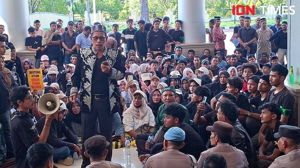 Seorang orator berbicara di depan massa aksi yang duduk di halaman Kantor Bupati Nagan Raya, Kecamatan Beutong Ateuh Banggalang.