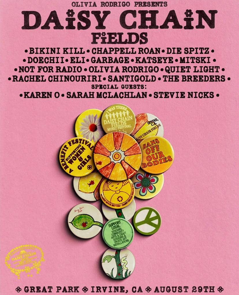 Poster festival musik Daisy Chain Fields berlatar merah muda dengan daftar penampil dan ilustrasi pin berbentuk bunga berwarna cerah.