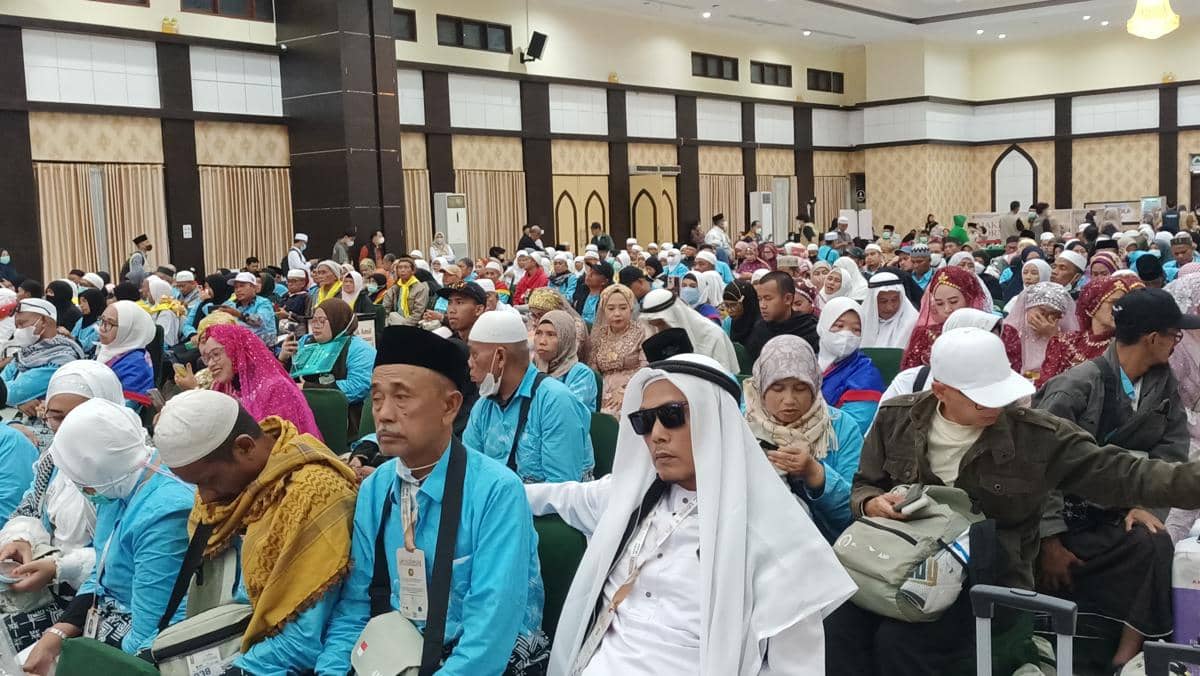 Ratusan jemaah haji Kloter 29 asal Papua mengenakan pakaian biru muda duduk di aula Asrama Haji Sudiang, Makassar, saat tiba dini hari.