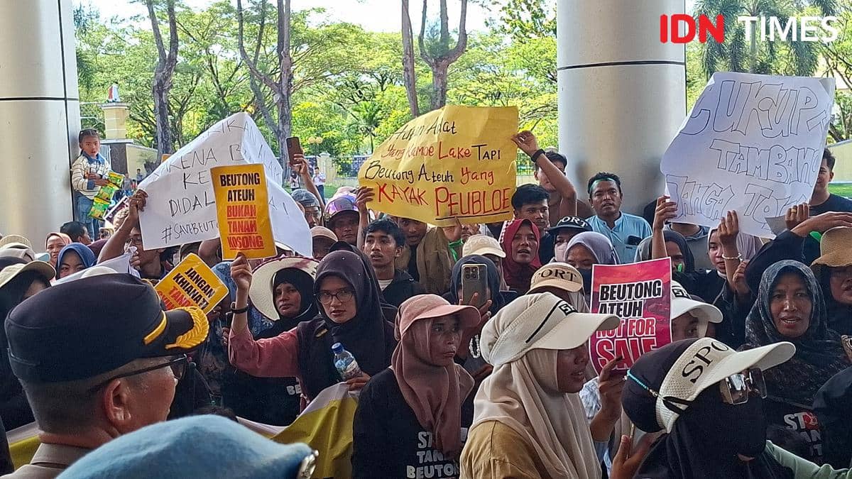 Massa aksi membawa poster dan spanduk saat berdemonstrasi di depan Kantor Bupati Nagan Raya, Kecamatan Beutong Ateuh Banggalang.