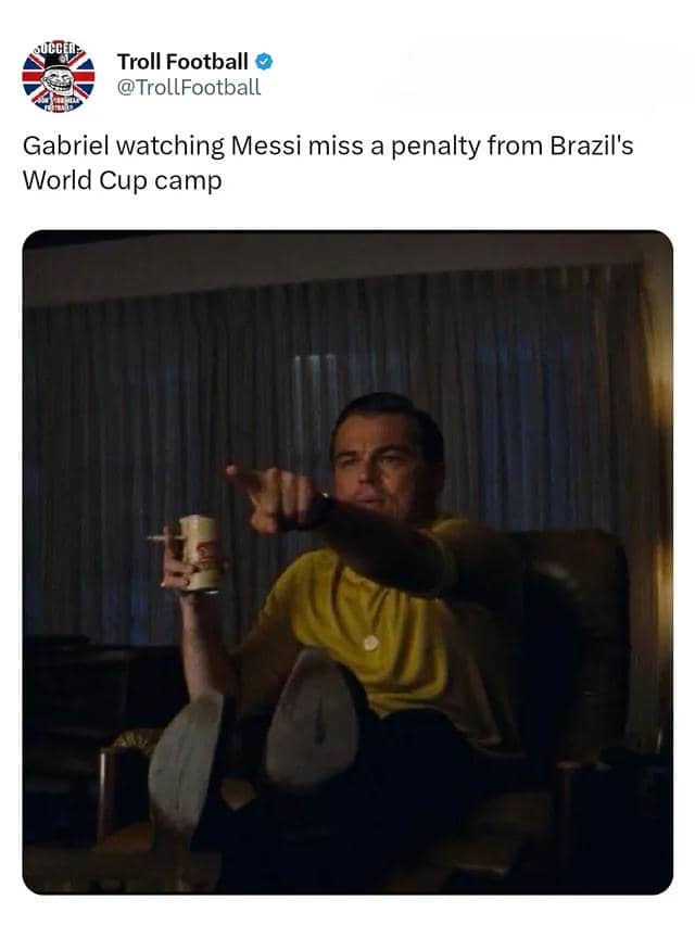 Seorang pria duduk di kursi sambil memegang minuman dan menunjuk ke layar televisi, digunakan sebagai meme tentang Lionel Messi gagal penalti.