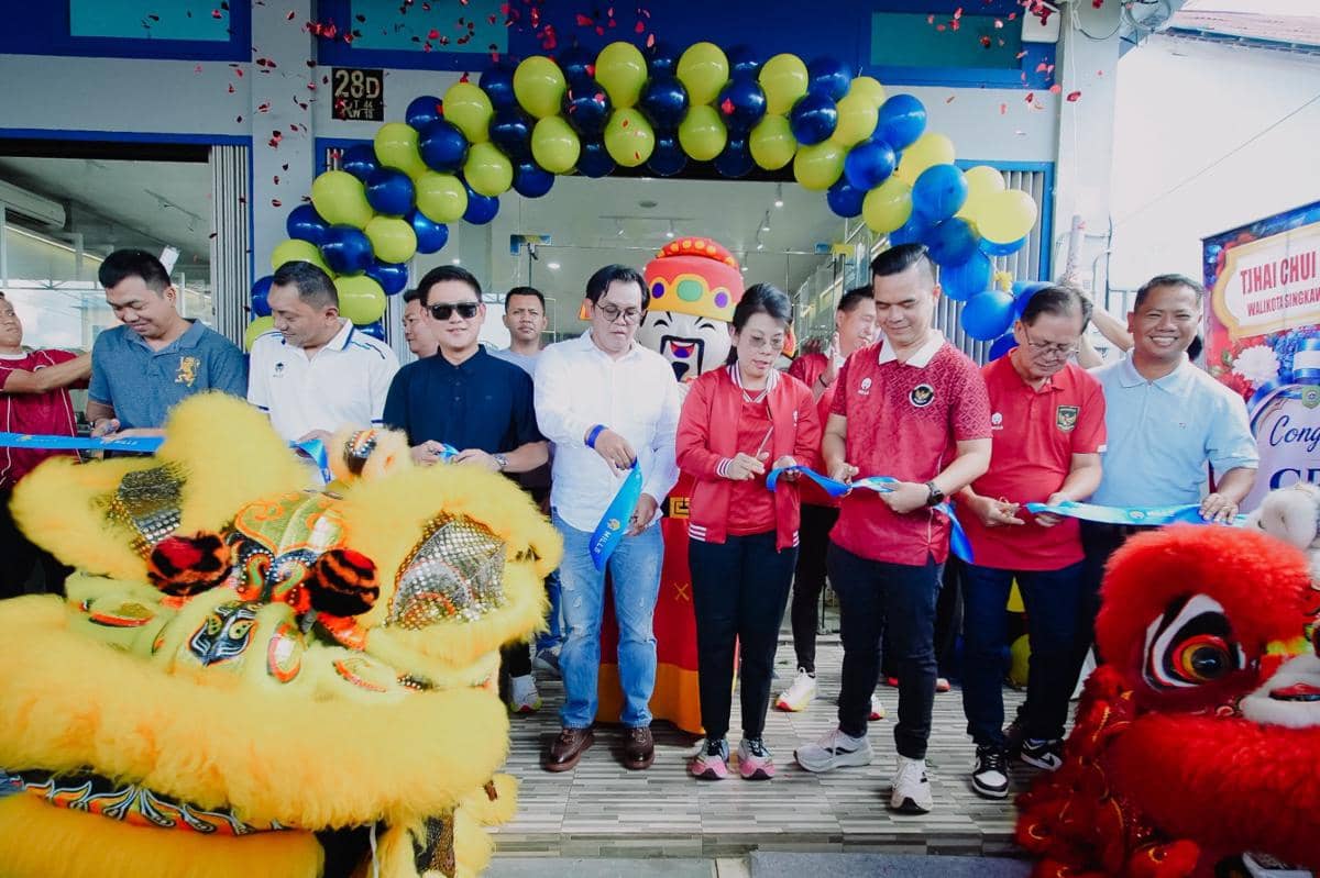 Peresmian toko Mills di Singkawang dengan pemotongan pita oleh sejumlah orang di depan gerbang balon biru kuning dan pertunjukan barongsai.