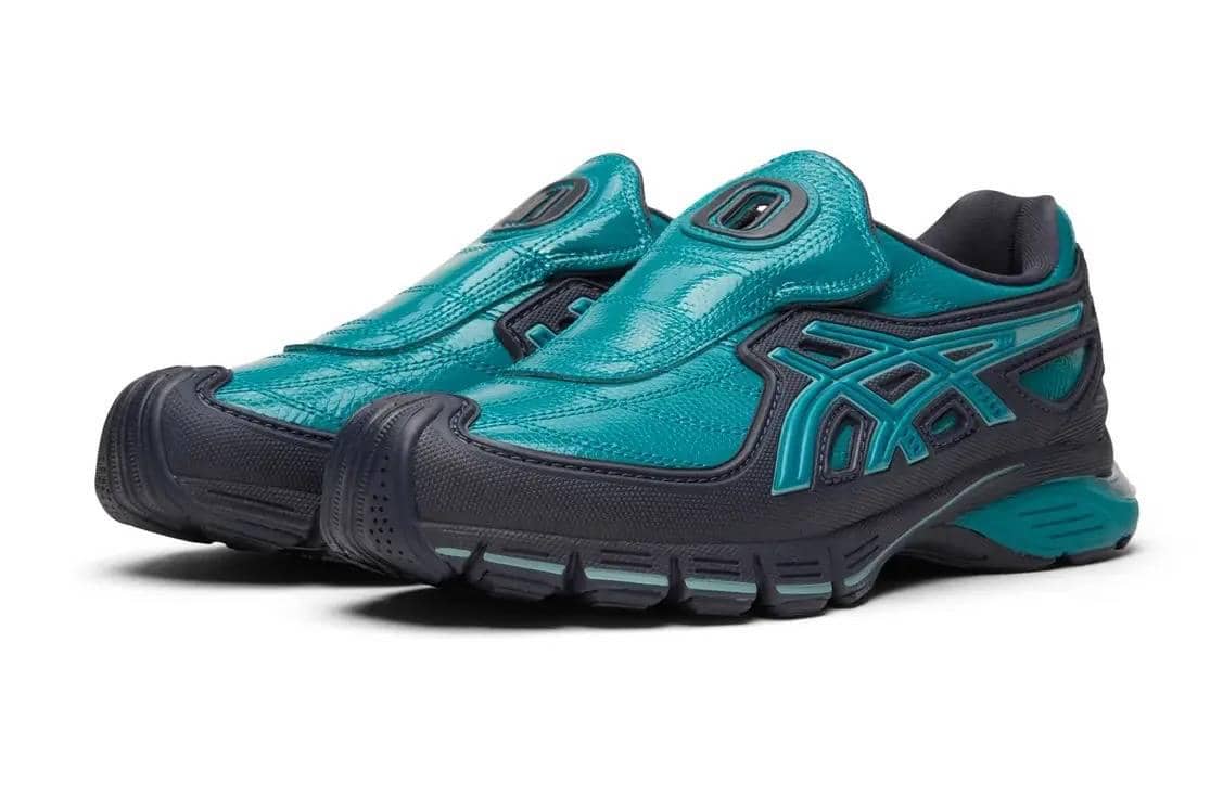 Sepasang sepatu ASICS Gel-SD Arzachotto x OTTO 958 berwarna biru toska dan hitam dengan desain modern tanpa tali.