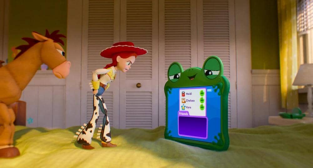 Jessie dan Bullseye berdiri di atas tempat tidur sambil melihat tablet berbentuk katak dalam adegan film animasi Toy Story 5.
