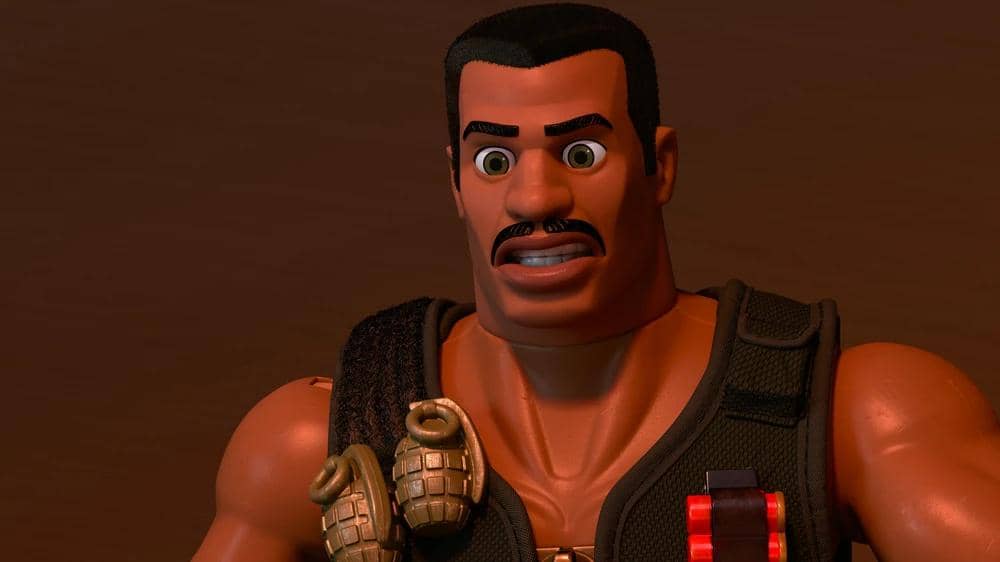 Karakter mainan pria berotot dengan rompi hitam dan granat di dada dari film animasi Toy Story 5 produksi Pixar.
