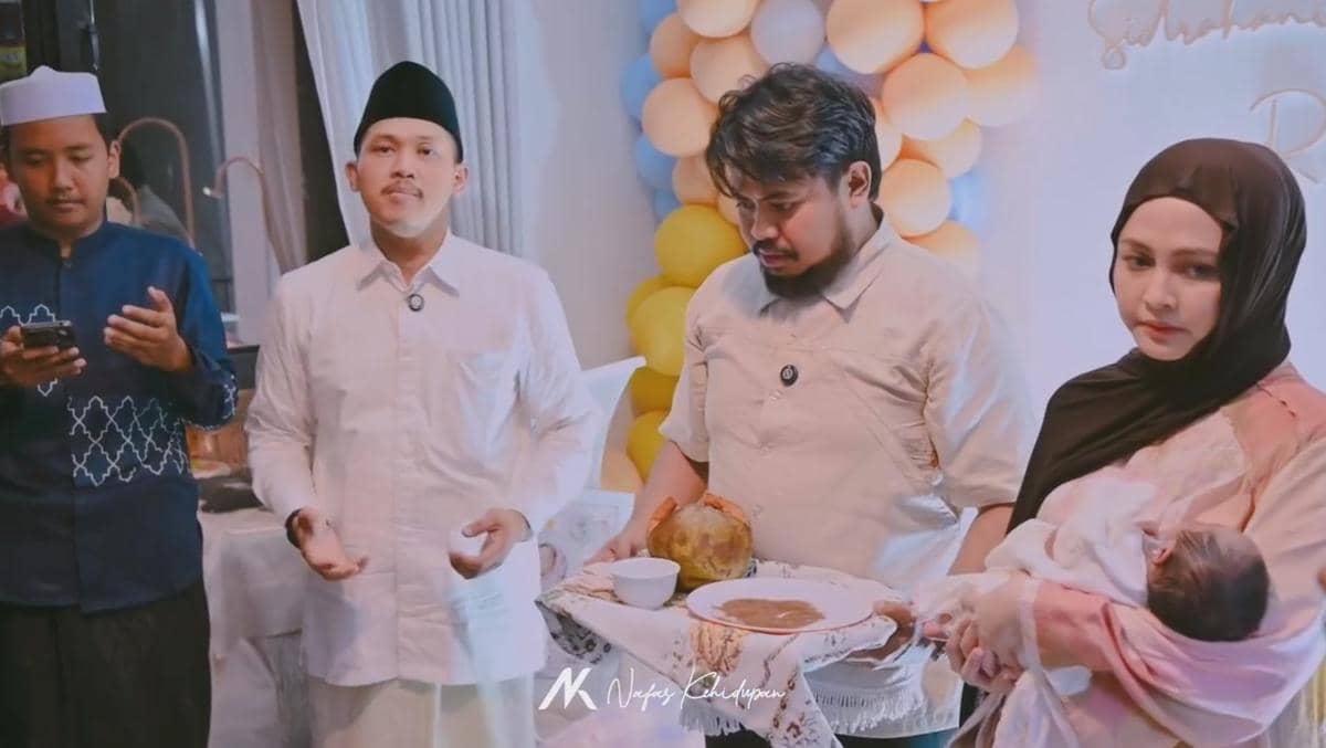 Suasana acara akikah anak keempat Rigen Rakelna dengan keluarga dan tamu mengenakan busana muslim di ruangan berhias balon warna pastel.