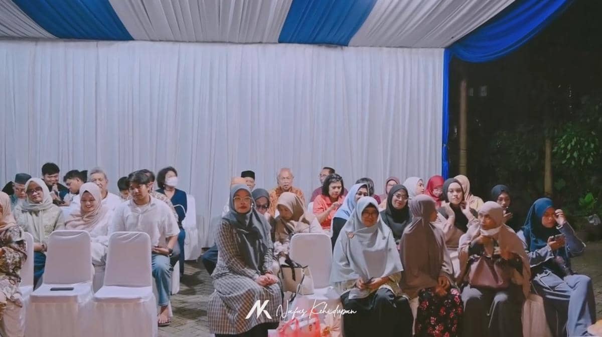 Para tamu duduk di bawah tenda putih dan biru saat acara akikah anak keempat Rigen Rakelna pada malam hari.