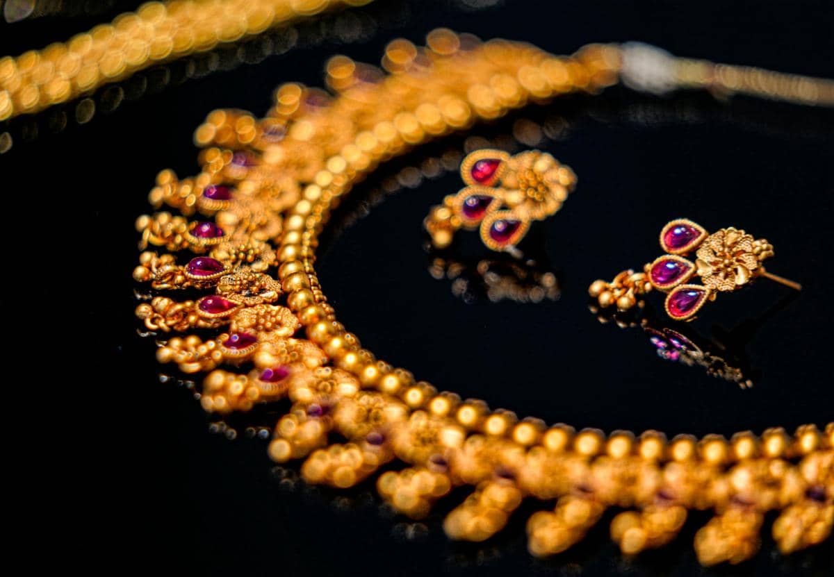 Ilustrasi perhiasan emas berwarna kuning keemasan tersusun sebagai koleksi aksesori bernilai dan berkilau.