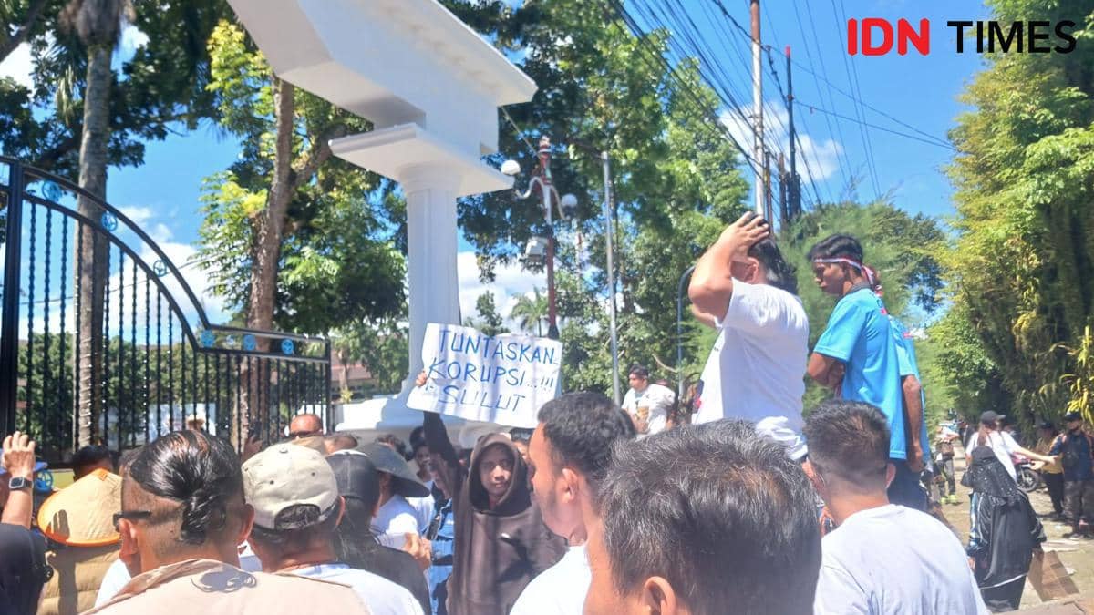 Sejumlah massa Mapalus Pragib melakukan aksi damai di depan Kantor Gubernur Sulawesi Utara di Manado sambil membawa poster tuntaskan korupsi.
