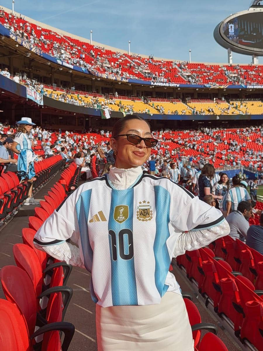 Seorang wanita mengenakan jersey tim nasional Argentina berdiri di tribun stadion Kansas City saat pertandingan fase grup Piala Dunia 2026.