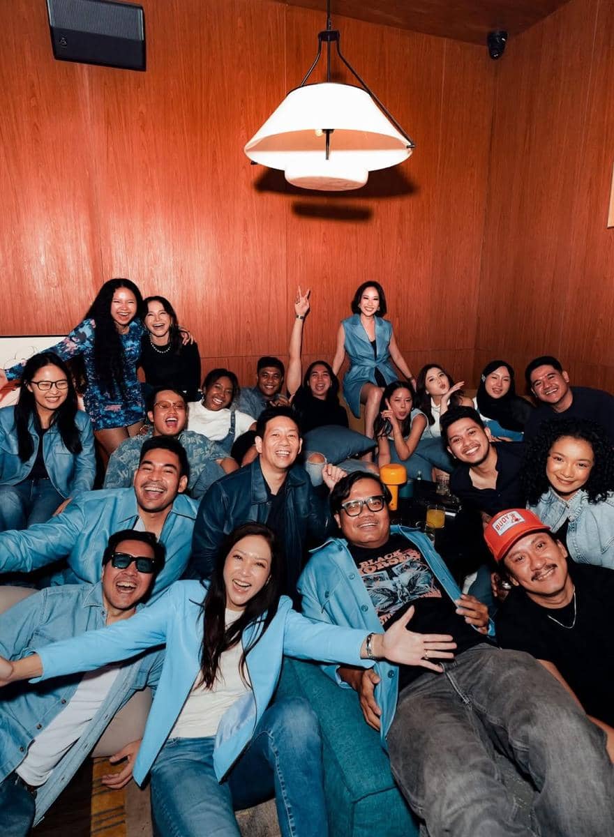 Para peserta dan kru Indonesian Idol Season 14 berpose bersama dengan ekspresi bahagia dalam pesta perpisahan di ruangan bernuansa kayu.