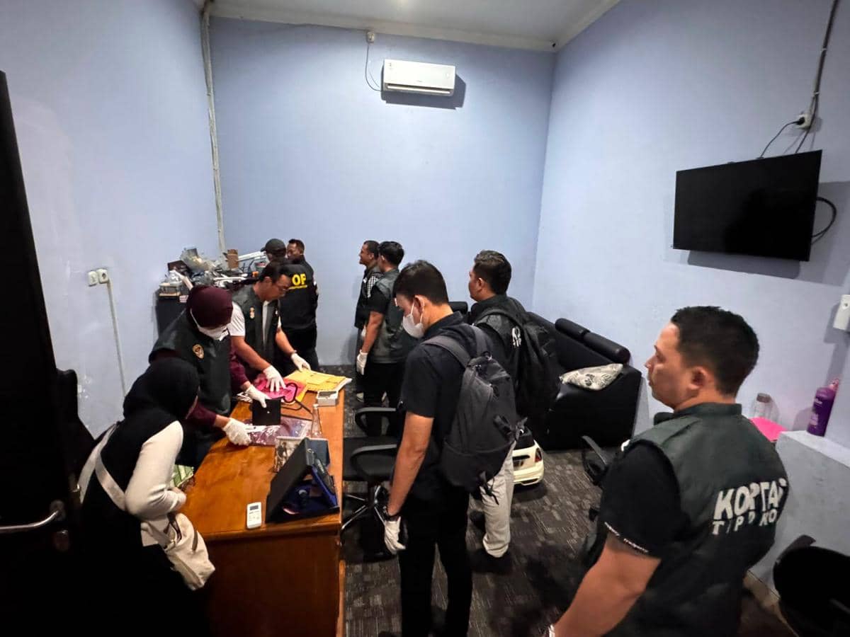 Petugas Kortas Tipikor Polri memeriksa dokumen dan barang bukti di sebuah ruangan saat penggeledahan terkait kasus dugaan korupsi impor handphone bekas ilegal.