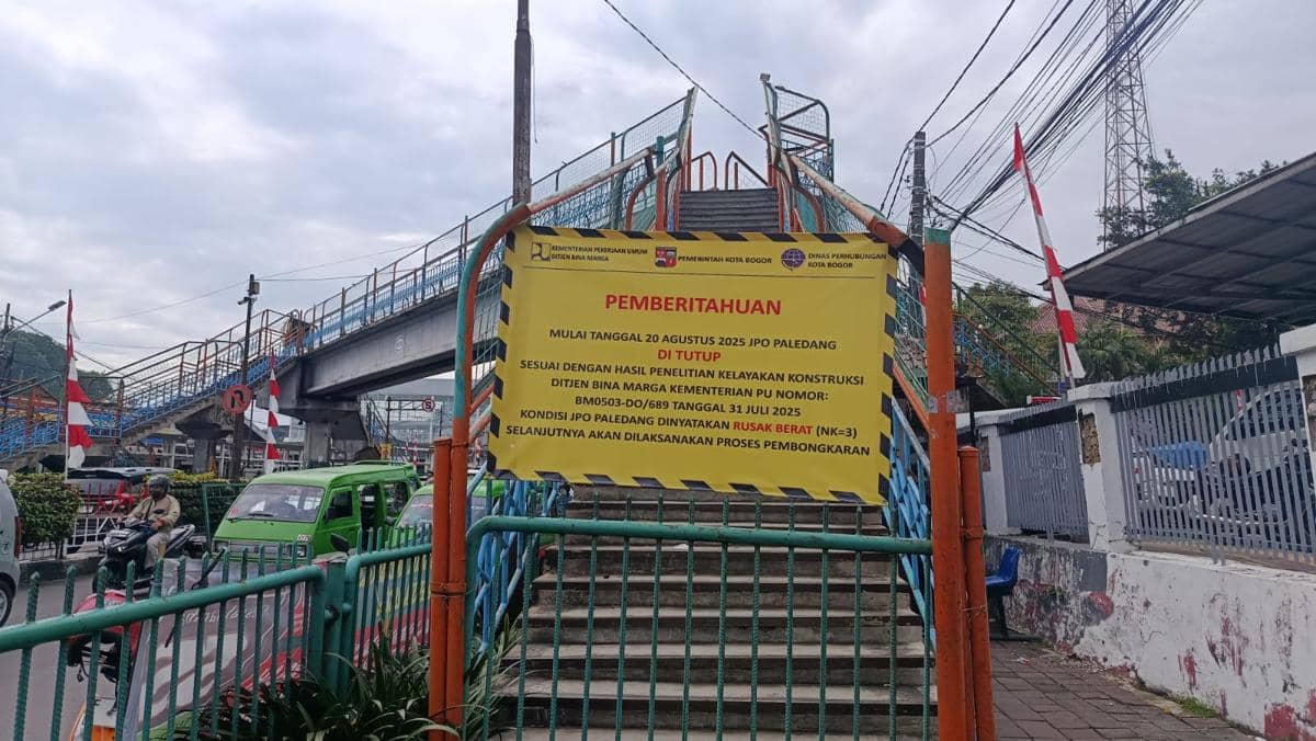 Papan pemberitahuan penutupan Jembatan Penyeberangan Orang Paledang di Bogor dengan latar jembatan dan lalu lintas kendaraan.