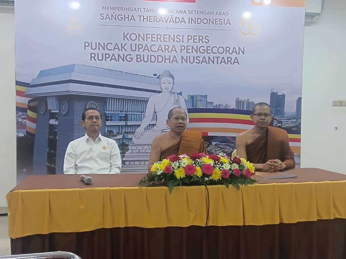 Tiga narasumber duduk di meja konferensi pers puncak upacara pengecoran Rupang Buddha Nusantara di Jakarta dengan latar spanduk acara.