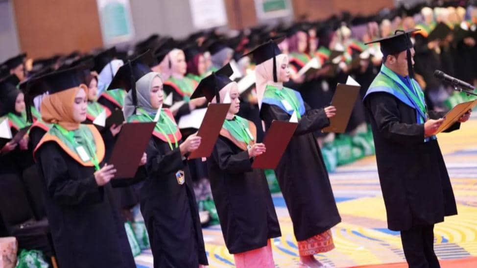 Para wisudawan Universitas Muslim Indonesia mengenakan toga dan membaca ikrar kelulusan dalam upacara wisuda di aula kampus.