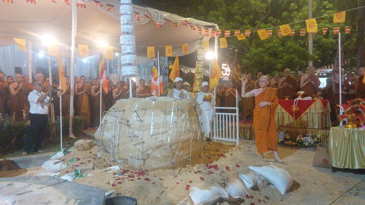 Para biksu dan peserta mengikuti prosesi pengecoran Ruppang Buddha Nusantara di Jakarta di bawah tenda berhias bendera dan lampu malam hari.