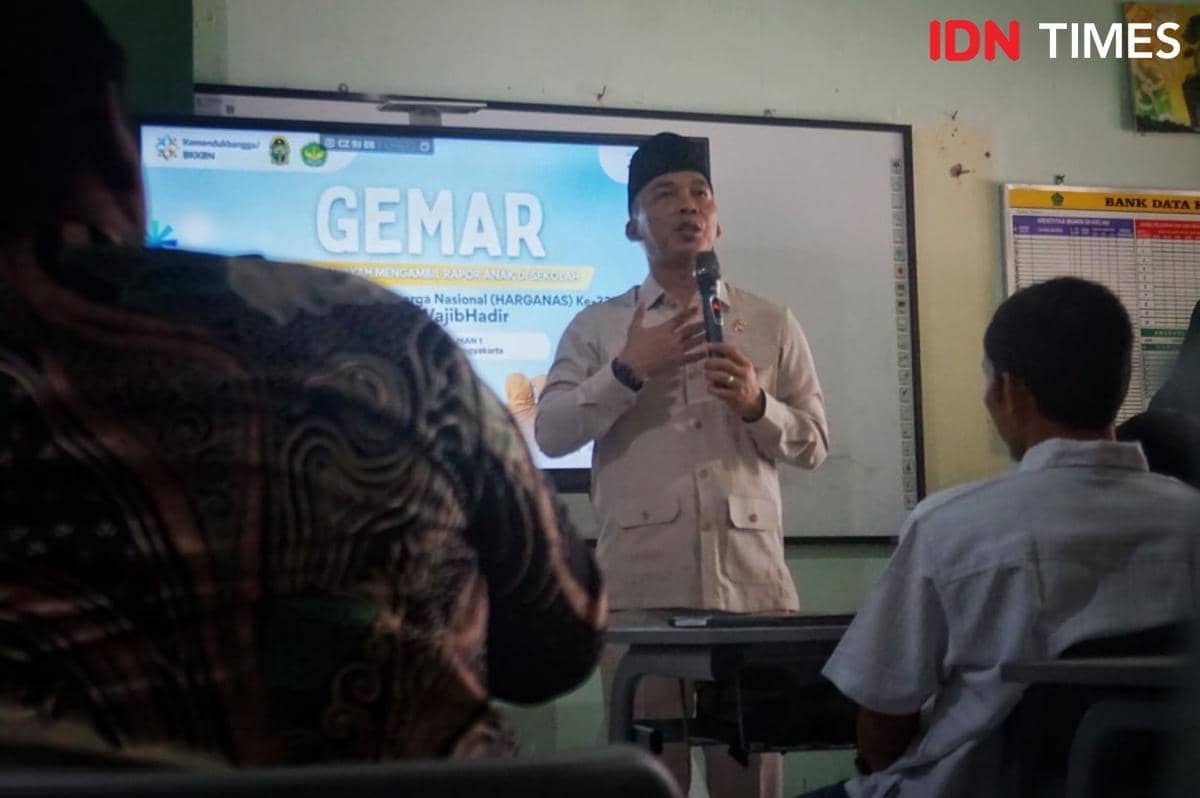 Seorang pejabat berbicara di depan siswa di ruang kelas MAN 1 Yogyakarta dengan latar layar presentasi bertuliskan GEMAR.