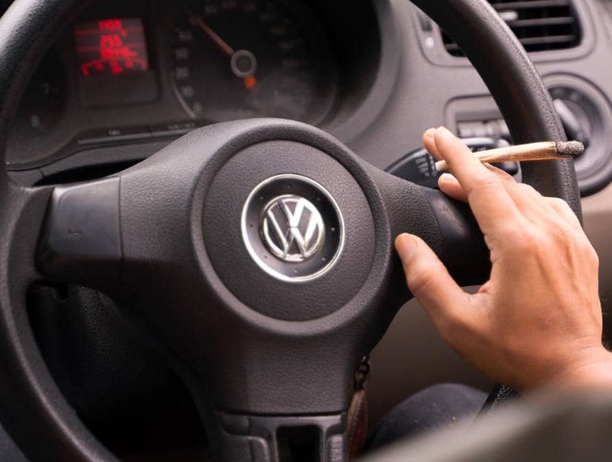 Ilustrasi seseorang merokok di dalam mobil dengan asap rokok memenuhi ruang kabin kendaraan yang tertutup.