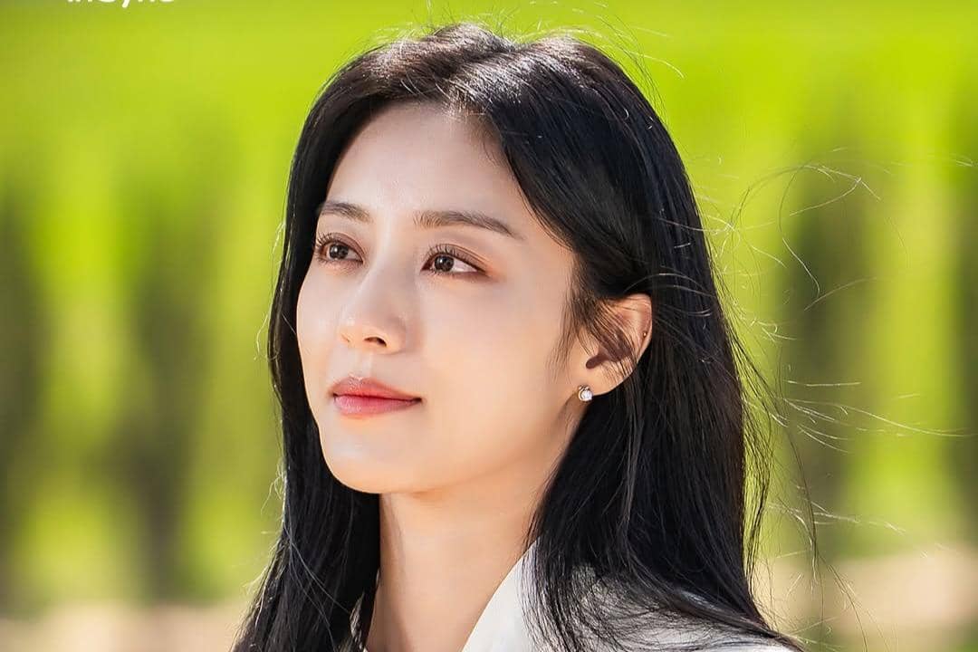 Seorang wanita berambut hitam panjang menatap ke arah cahaya dengan latar pepohonan hijau dalam adegan drama Love In Sync.