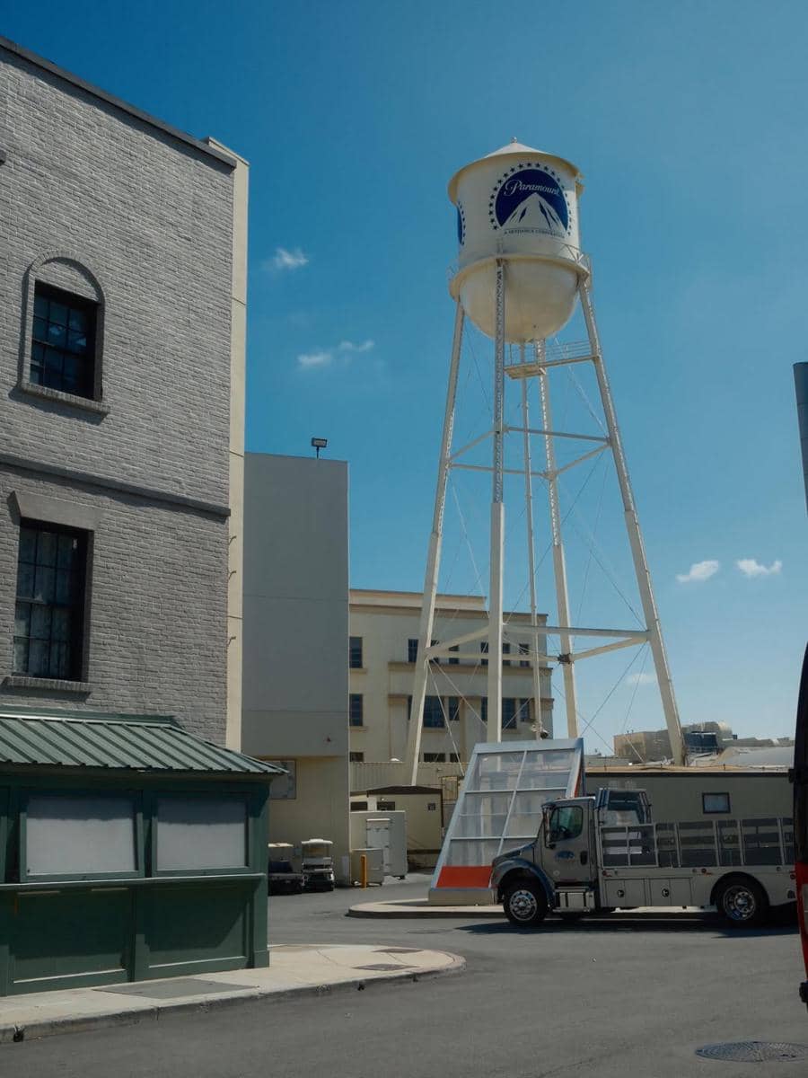 Menara air putih dengan logo Paramount berdiri di antara gedung-gedung studio di kawasan Hollywood pada siang hari yang cerah.