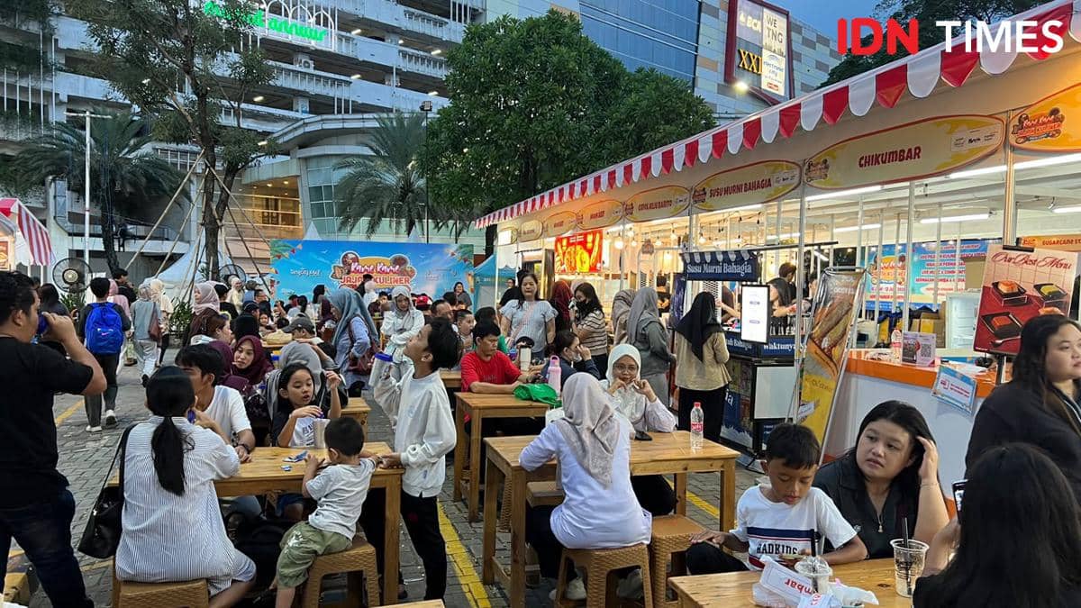 Suasana ramai pengunjung menikmati kuliner di area luar TangCity Mall dengan deretan stan makanan dan meja kayu untuk bersantai.