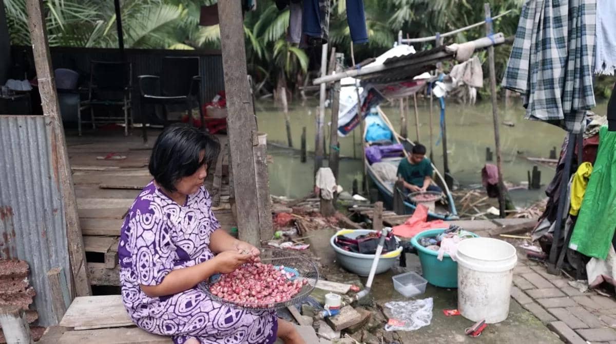 Aktivitas sehari-hari Marhani sebagai pengupas bawang di rumahnya, di bantaran anak Sungai Tallo, di Kelurahan Pampang, Kecamatan Panakkukan