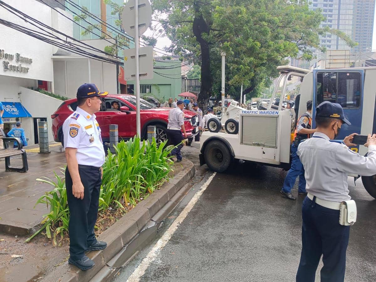 Suku Dinas Perhubungan Kota Administrasi Jakarta Selatan menderek mobil mewah yang parkir liar di di kawasan Jalan Senopati dan Jalan Gunawarman, Kebayoran Baru, Kamis (25/6) sore