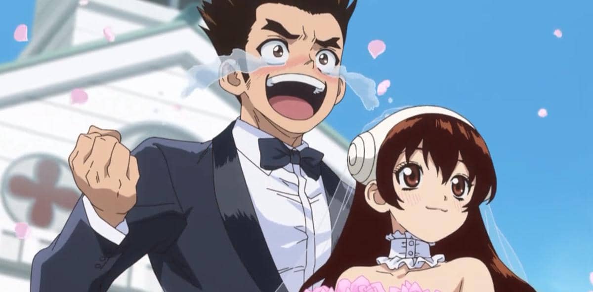 Dua karakter anime mengenakan pakaian pengantin, pria dengan setelan jas hitam dan wanita dengan gaun putih, tersenyum bahagia di luar gedung.