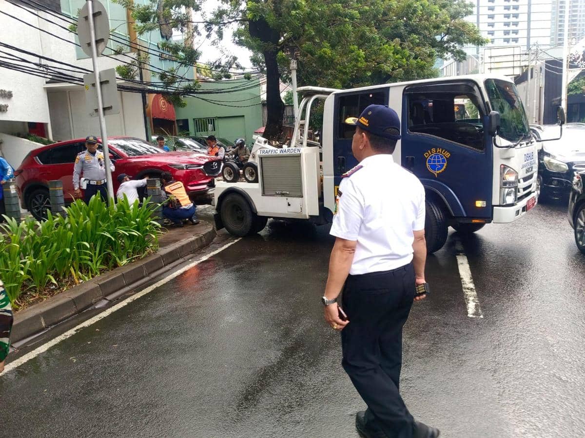 Suku Dinas Perhubungan Kota Administrasi Jakarta Selatan menderek mobil mewah yang parkir liar di di kawasan Jalan Senopati dan Jalan Gunawarman, Kebayoran Baru, Kamis (25/6) sore. 