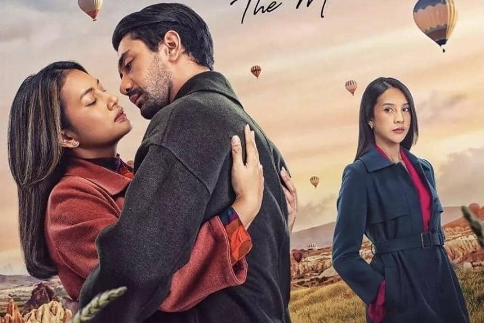 Poster film Layangan Putus: The Movie menampilkan dua orang berpelukan dengan latar balon udara dan seorang wanita berdiri di kejauhan.