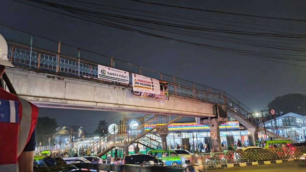 Jembatan penyeberangan orang Paledang di dekat Stasiun Bogor pada malam hari dengan lalu lintas dan aktivitas warga di sekitarnya.