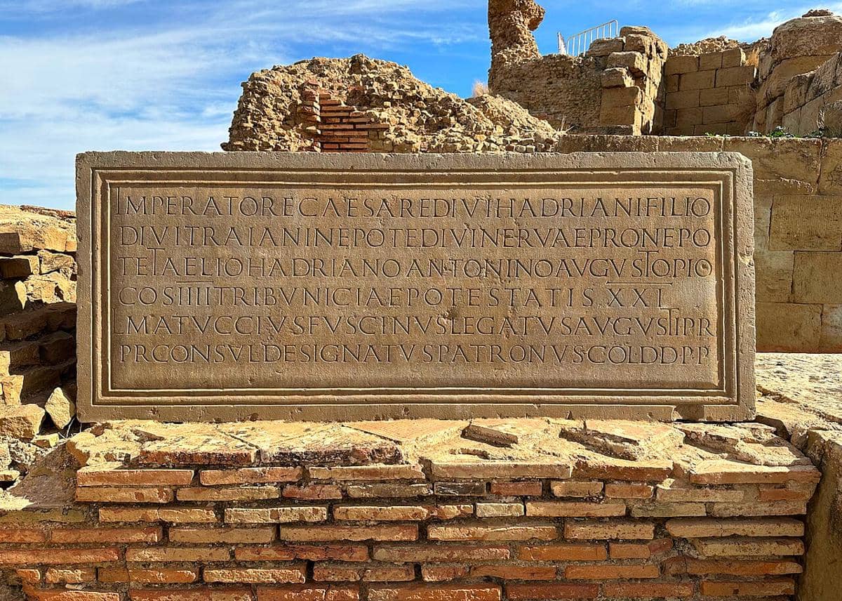 Prasasti Romawi dari tahun 158–159 M yang ditemukan di situs arkeologi Timgad, Aljazair, dekat teater kuno.