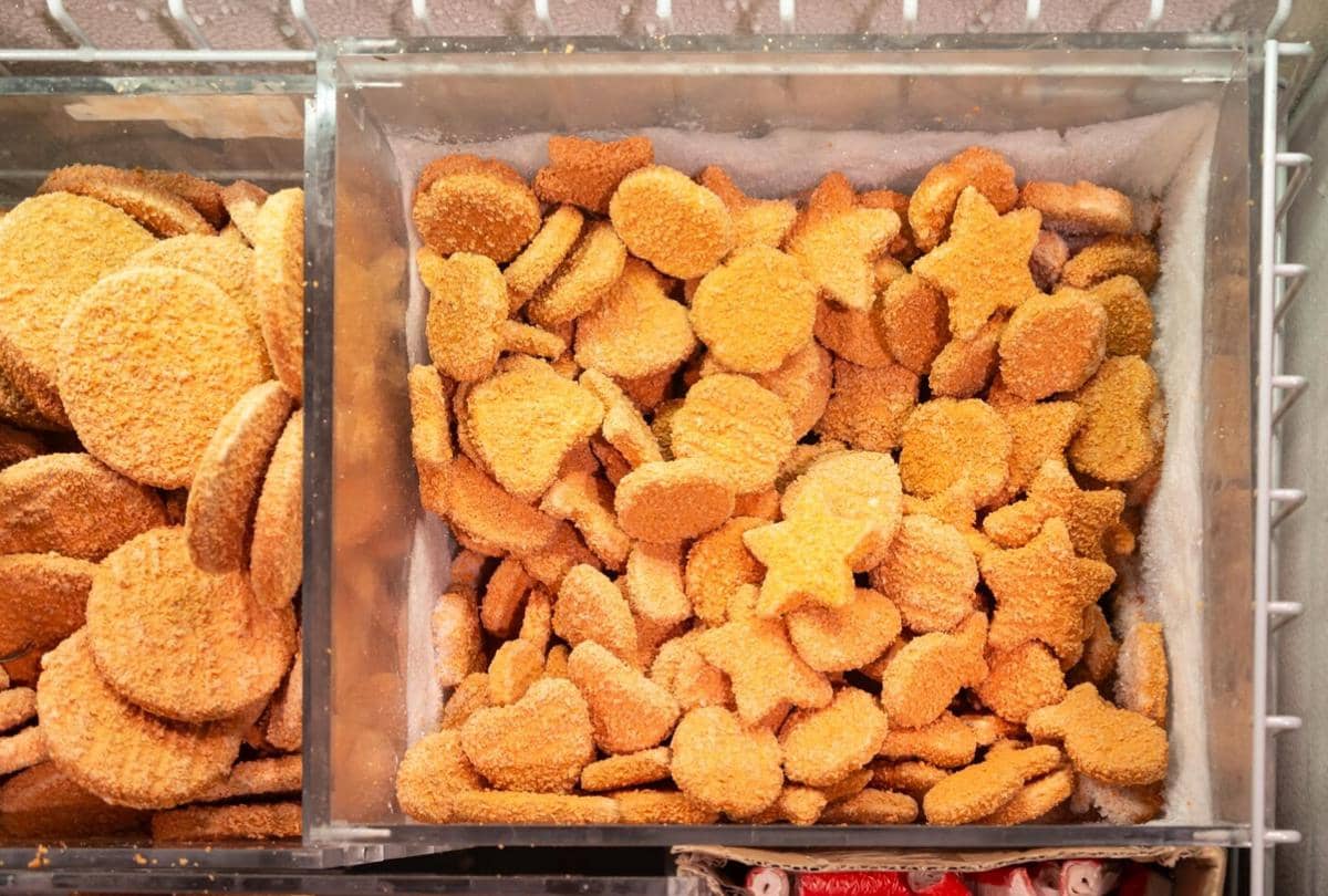 Beragam frozen food berbentuk bulat dan bintang tersimpan dalam wadah pendingin di toko makanan beku.
