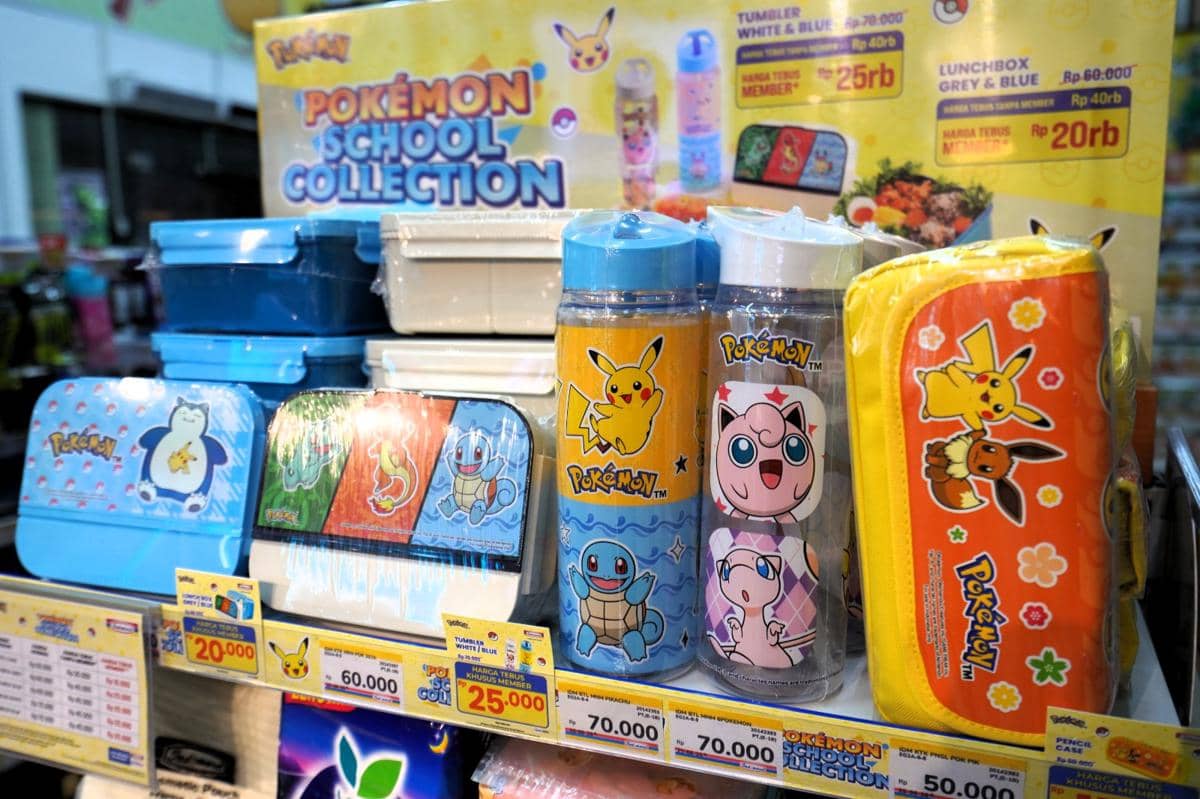 Produk kolaborasi Pokemon dan Indomaret berupa botol minum, kotak makan, serta tempat pensil dengan desain karakter Pokemon berwarna cerah.