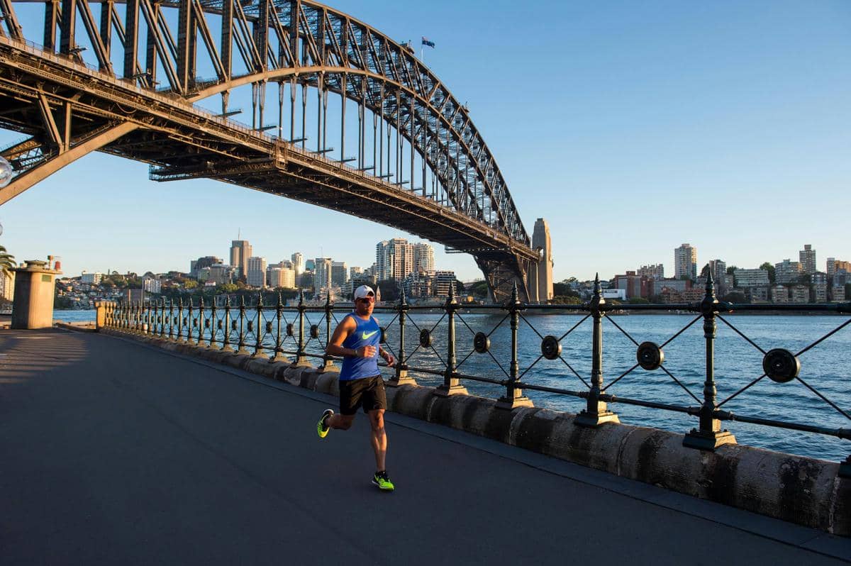 Potret seseorang sedang berlari di bawah Sydney Harbour Brigde, Sydney, Australia