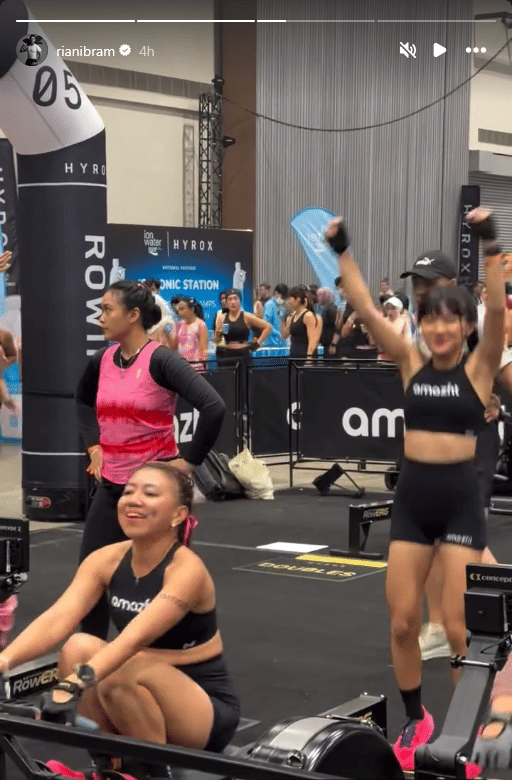 Peserta wanita berolahraga di acara HYROX Jakarta 2026 Day 2, dengan suasana ramai dan penuh semangat di area kompetisi indoor.