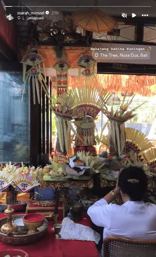 Seorang wanita berpakaian adat Bali duduk di depan sesajen dan hiasan janur saat perayaan Hari Raya Kuningan di Nusa Dua, Bali.