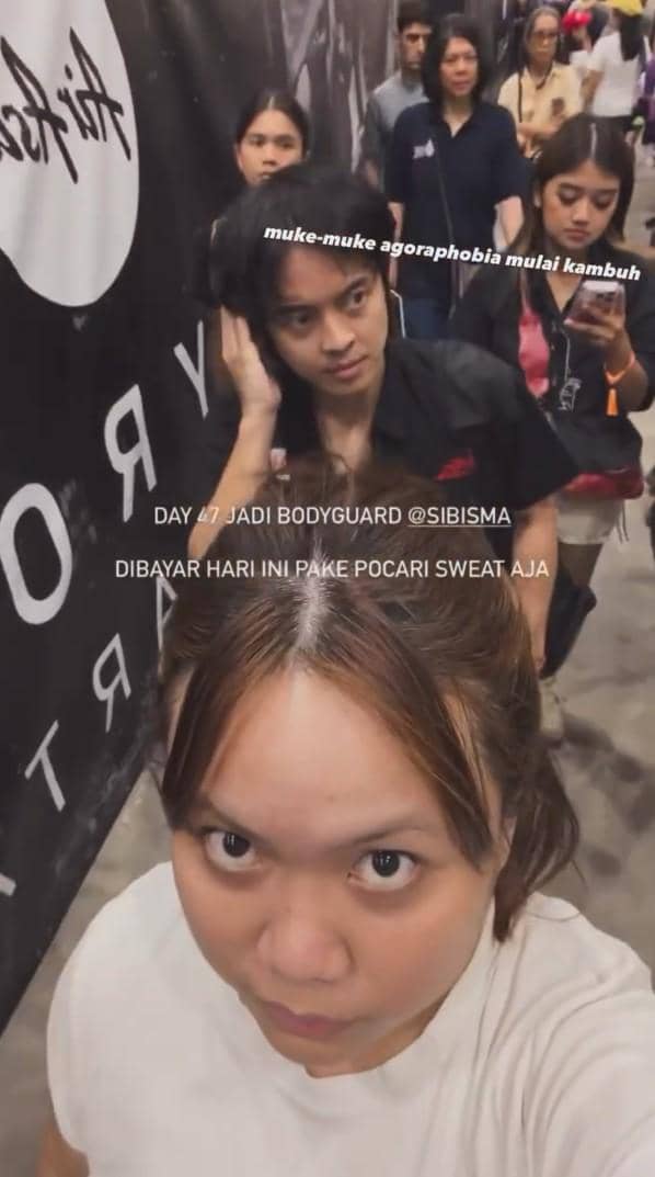 Seorang wanita dan pria berjalan di area acara HYROX Jakarta 2026 Day 2 dengan latar belakang peserta lain di koridor ramai.