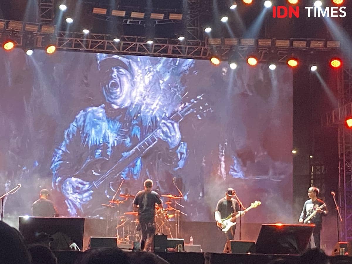 Band Seringai tampil di panggung Localfest 2026 dengan pencahayaan panggung berwarna oranye dan latar visual besar bergambar pemain gitar.