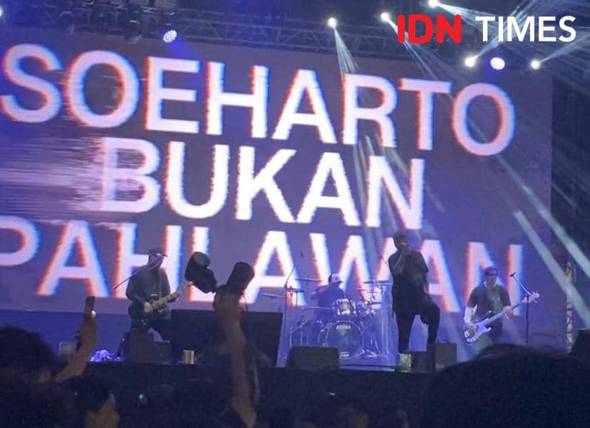 Band Seringai tampil di panggung Localfest 2026 hari pertama dengan latar layar besar bertuliskan pesan provokatif dan pencahayaan panggung berwarna biru.
