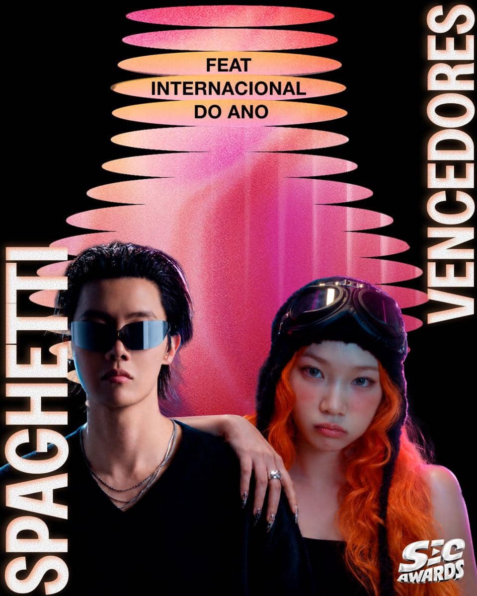 Dua anggota grup musik berpose dengan gaya futuristik mengenakan kacamata hitam dan aksesori unik di poster penghargaan SEC Awards 2026.