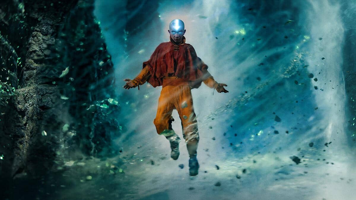 Seorang biksu muda dengan tato panah biru di kepalanya melayang di tengah pusaran energi biru dalam adegan Avatar: The Last Airbender Season 2.