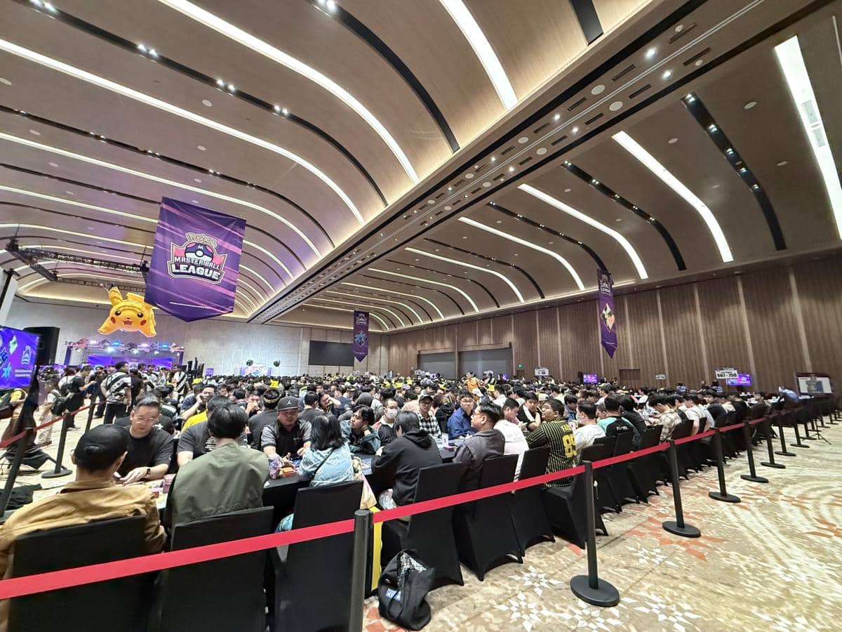 Ratusan peserta duduk di meja besar dalam turnamen Indonesia Master Ball League di aula luas dengan dekorasi bertema permainan.