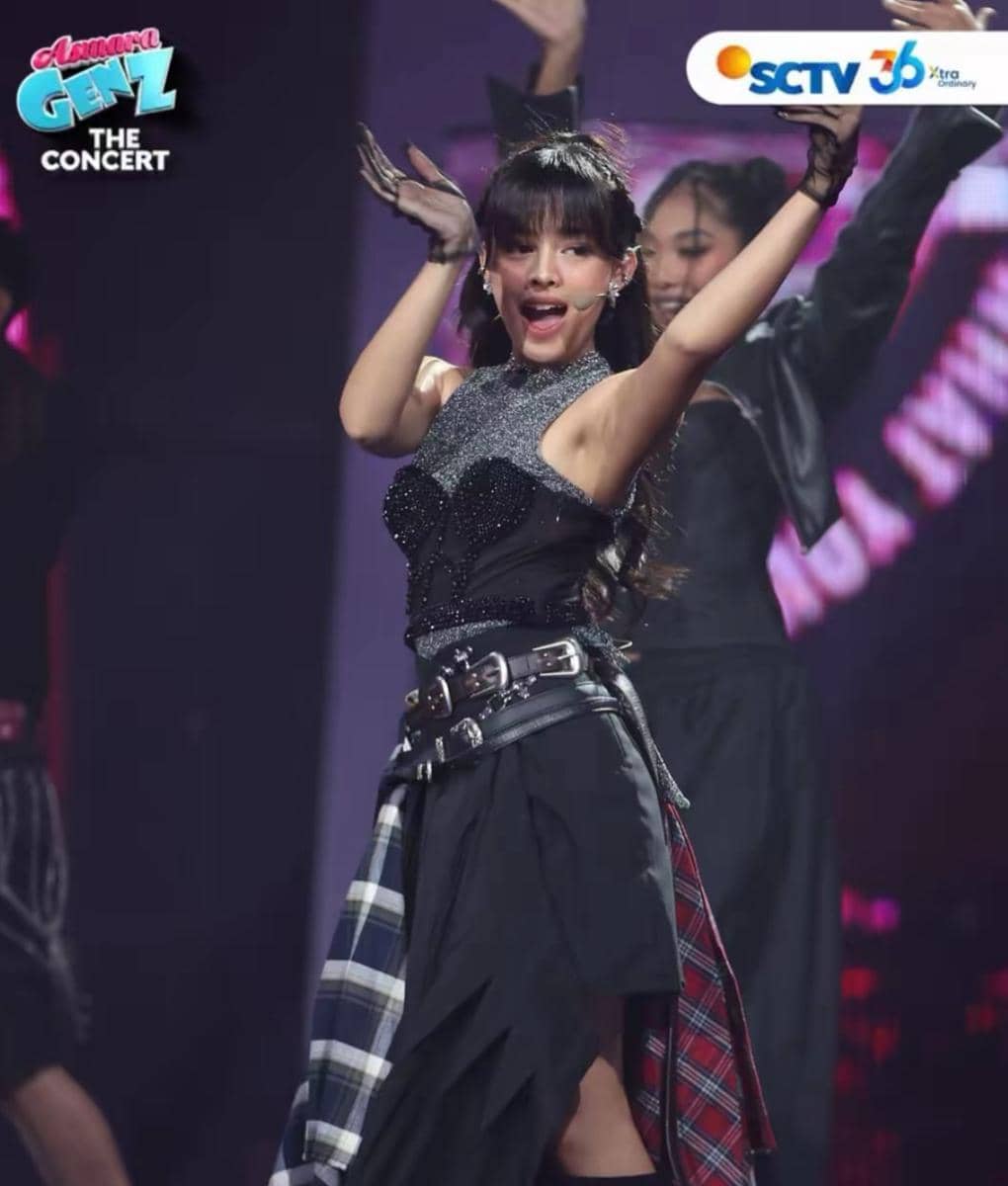 Seorang penyanyi muda tampil energik di panggung Asmara Gen Z The Concert dengan busana hitam dan aksen kotak-kotak.