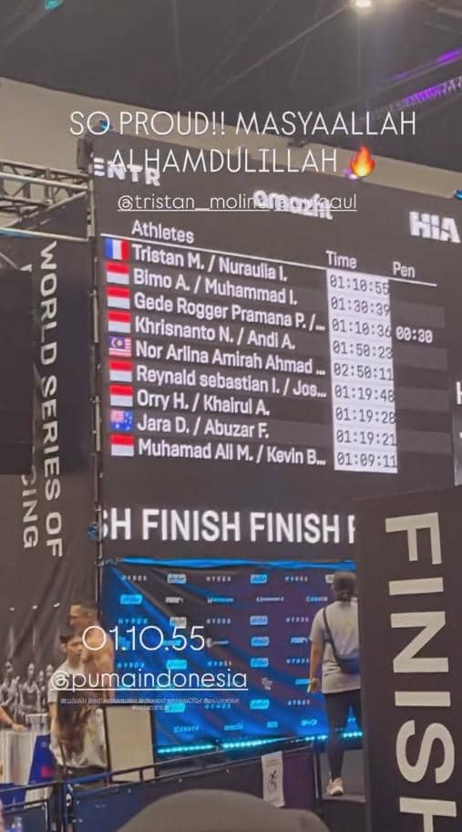 Layar besar menampilkan hasil lomba HYROX Jakarta 2026 dengan daftar nama atlet dan waktu penyelesaian di area finis dalam ruangan.