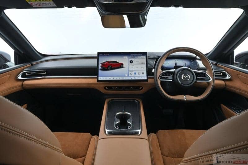 Interior Mazda 6e versi RHD dengan desain mewah, layar sentuh besar di tengah, dan setir di sisi kanan berbalut kulit cokelat.